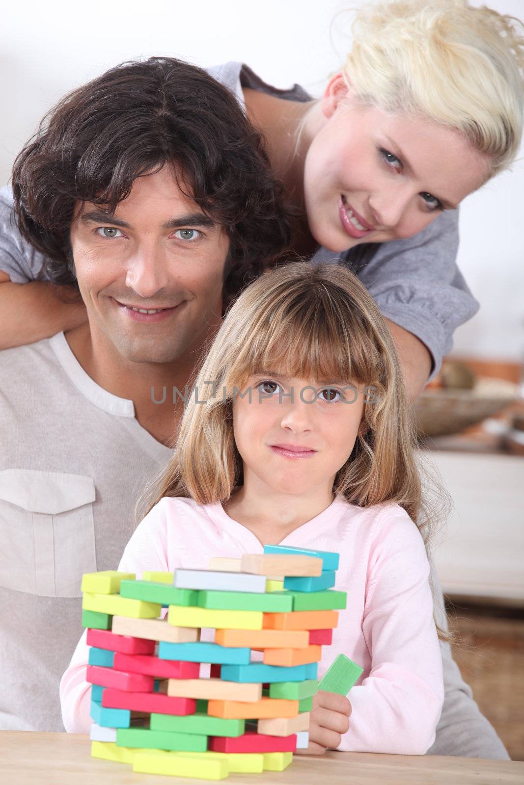 Couple playing a stacking game with their daughter