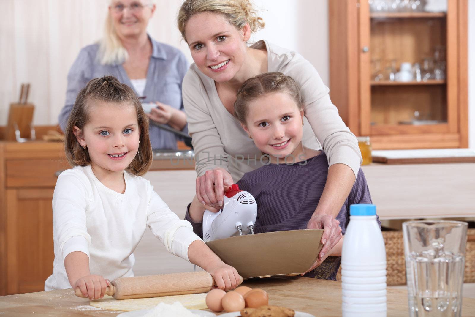 Three generations of women baking. by phovoir