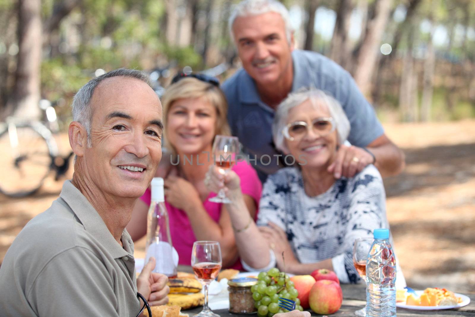 Older people eating in a field by phovoir