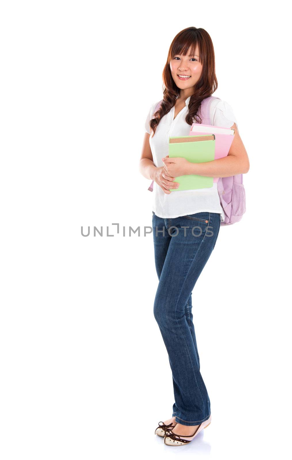 Full body portrait of smiling Asian female young adult student standing isolated on white background