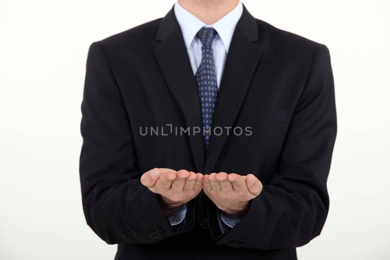 Businessman holding his hands straight palm-side up by phovoir