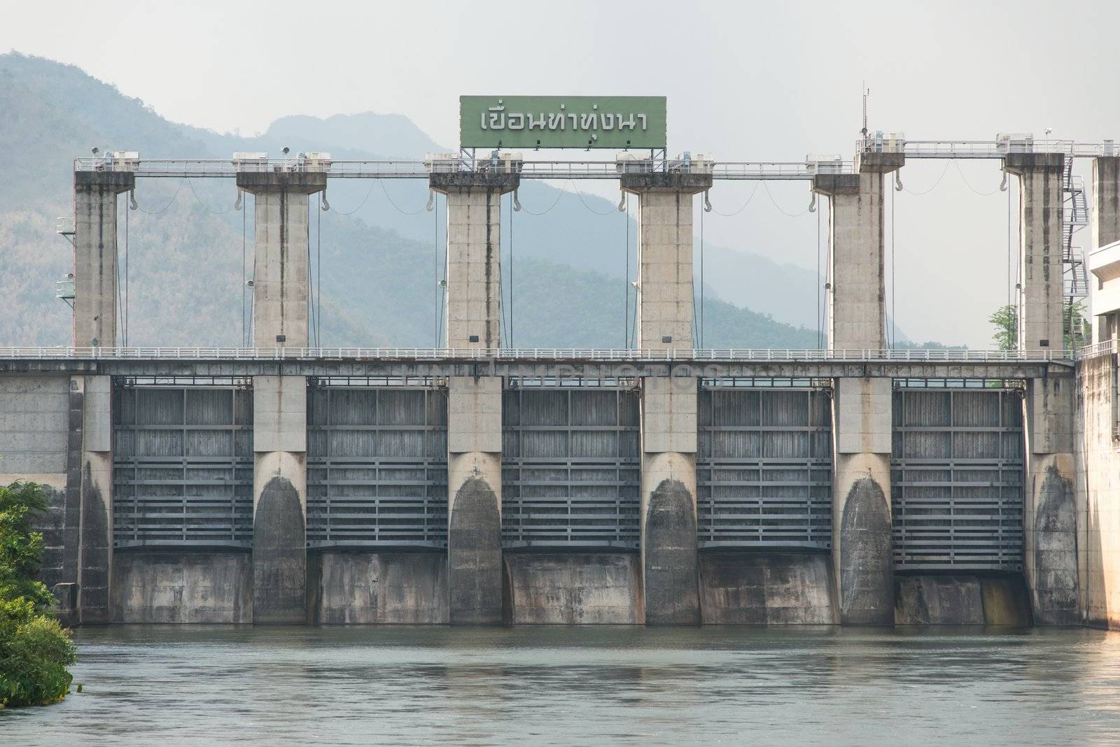 Medium size dam with metal water gate in Thailand, taken on a cloudy day