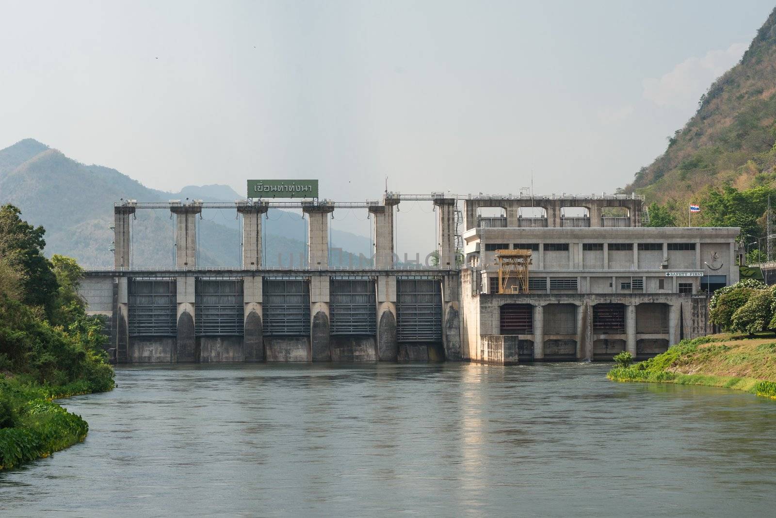 Medium size dam with metal water gate in Thailand, taken on a cloudy day