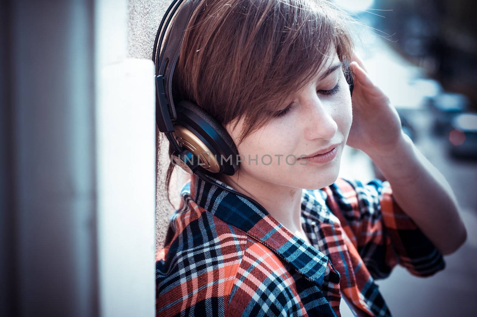 young hipster woman listening to music on balcony
