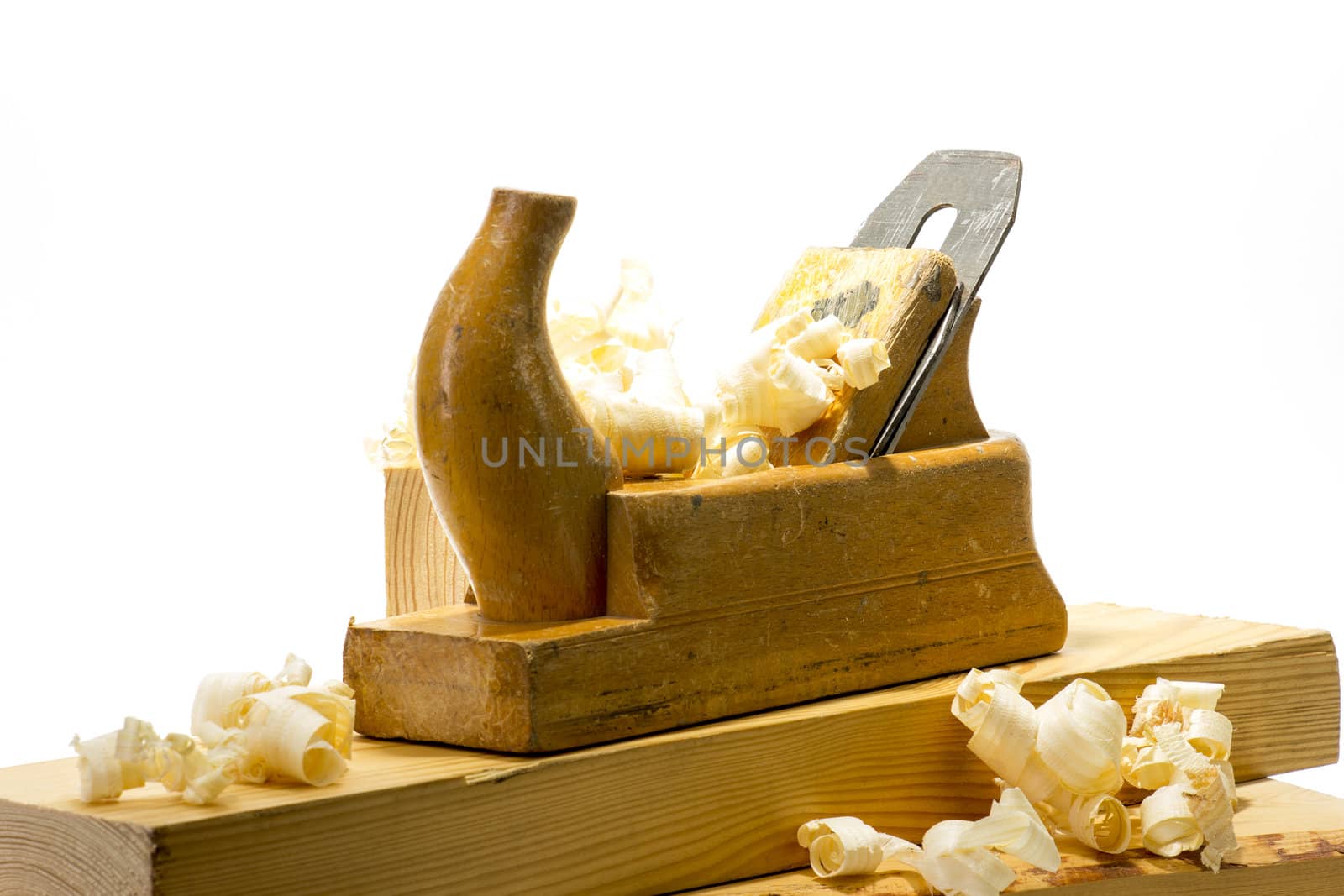 Wooden plane, boards and planed wood shavings on a white background