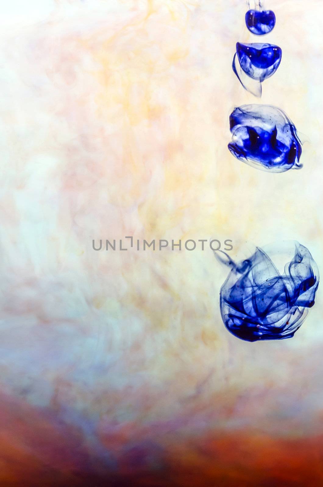 Blue ink in colored water on white background.