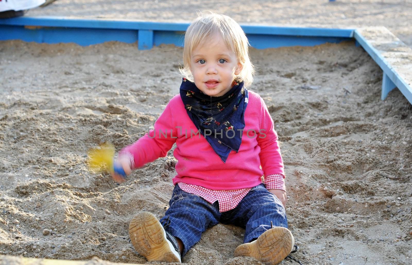two years old blonde blue eyes beautiful kid at the playground