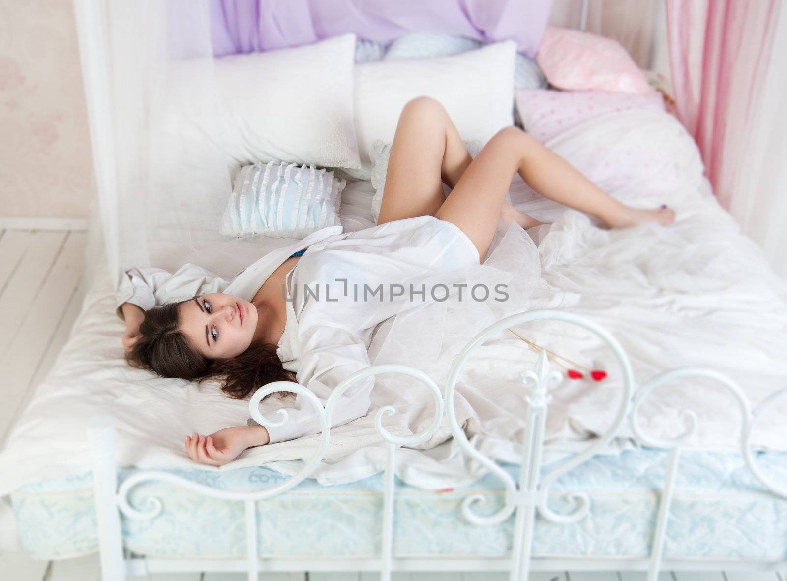 beautiful woman in bed in a white shirt