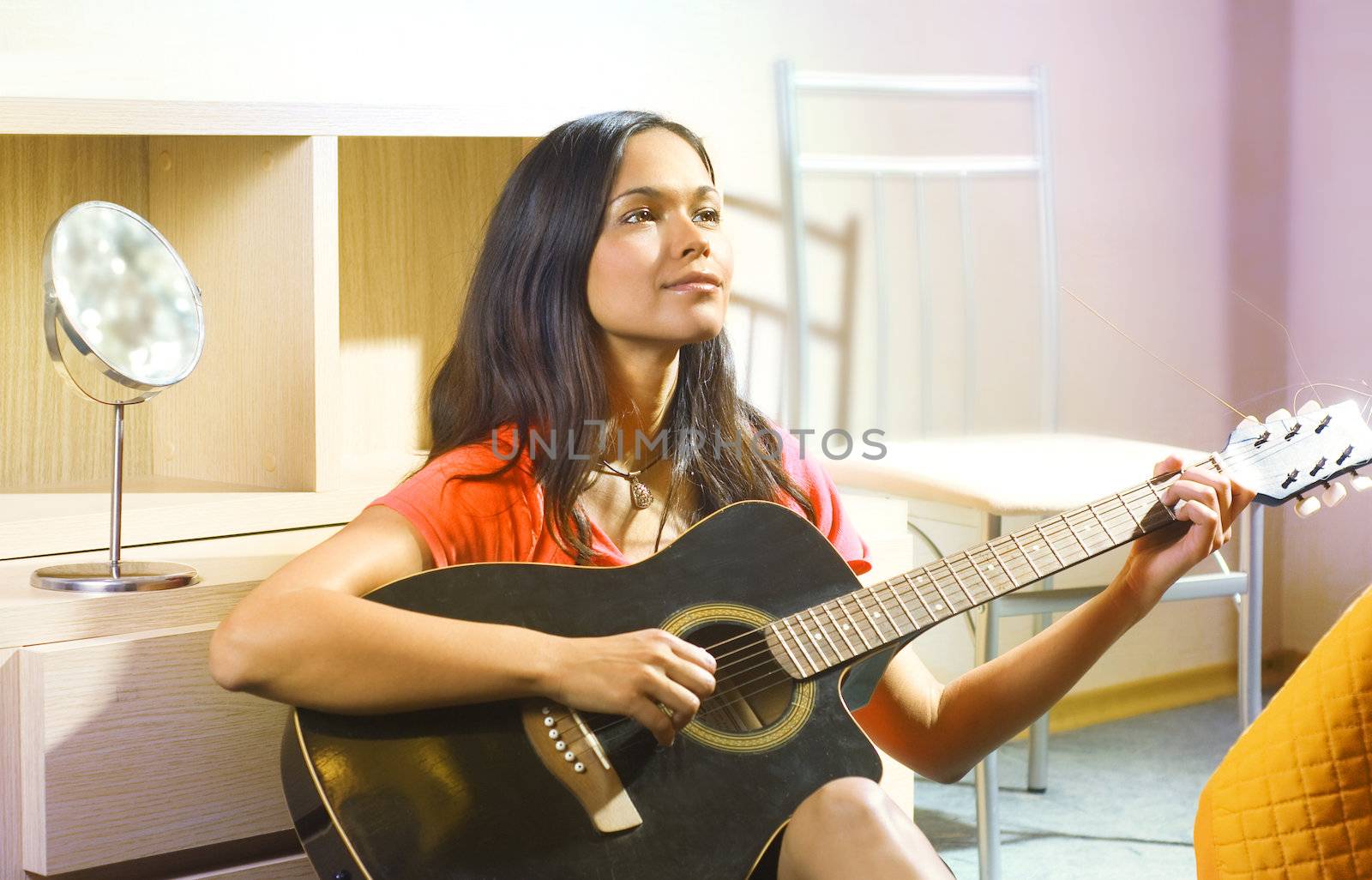 beautiful young lady in a room with guitar