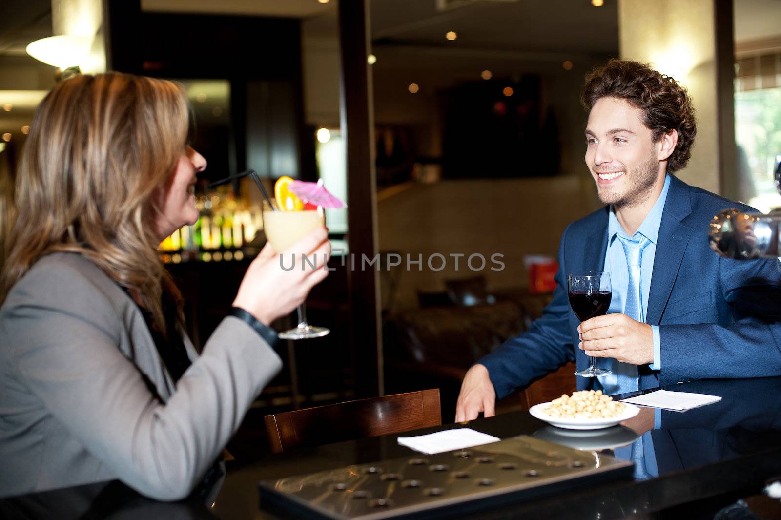 Friends enjoying cocktail at the bar and gossipping