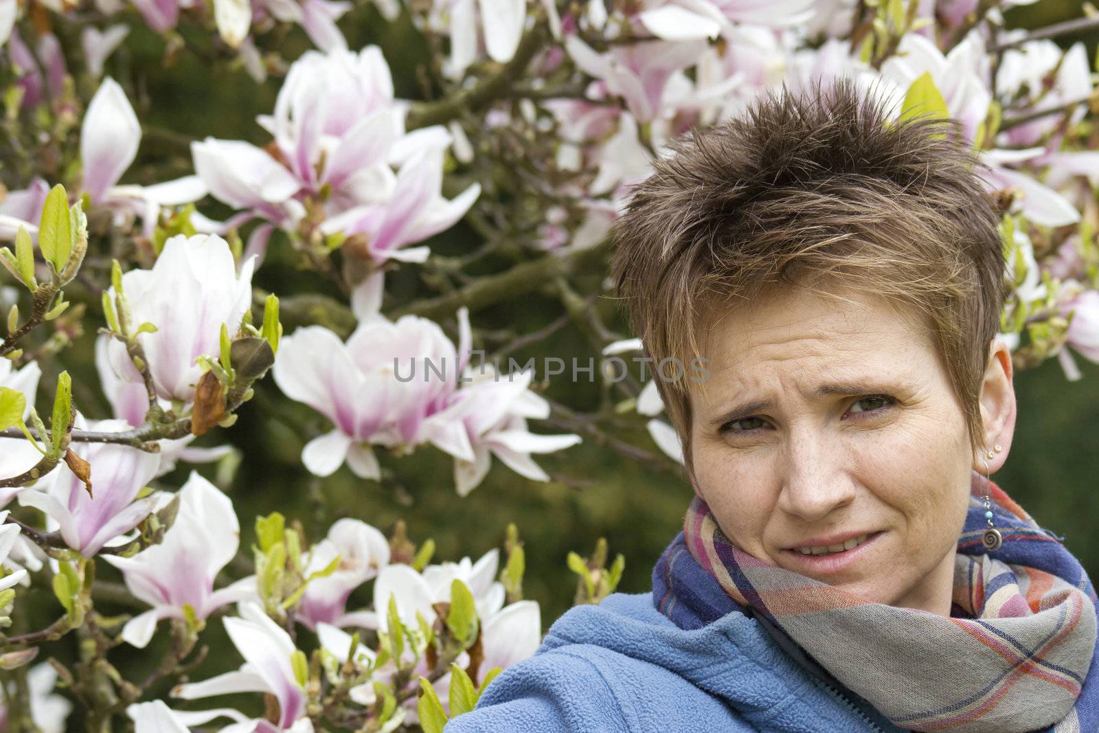 portrait of woman with blooming magnolia on background 