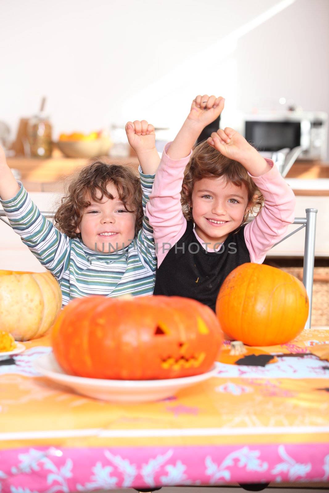 Happy children with carved pumpkins by phovoir