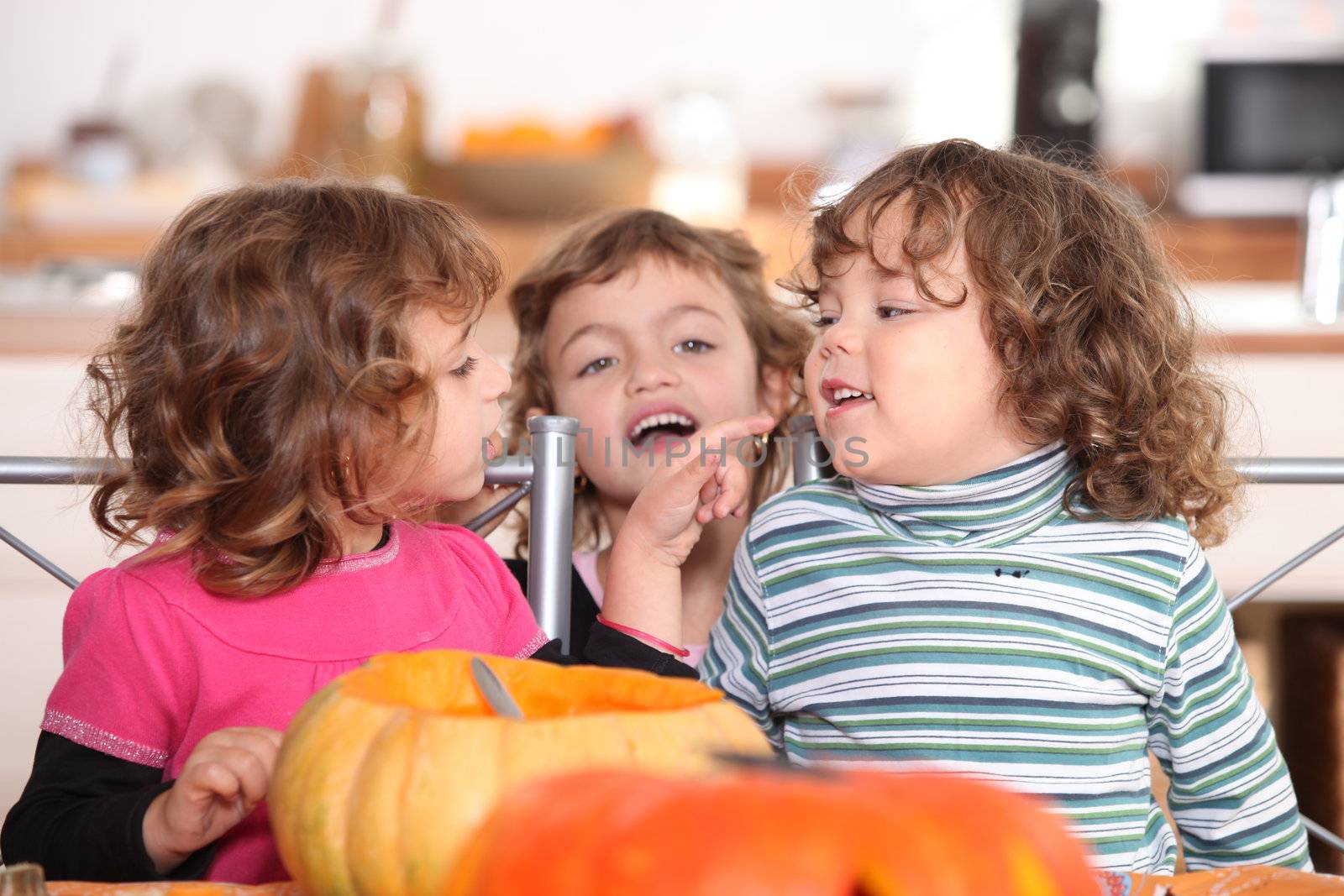 three kids in a kitchen at Halloween time by phovoir