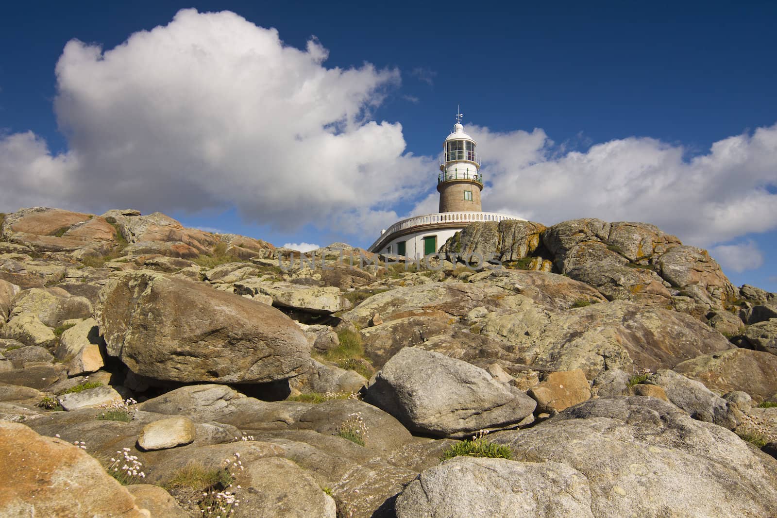 Corrubedo Lighthouse with blue sky and rocks, Galicia, Spain