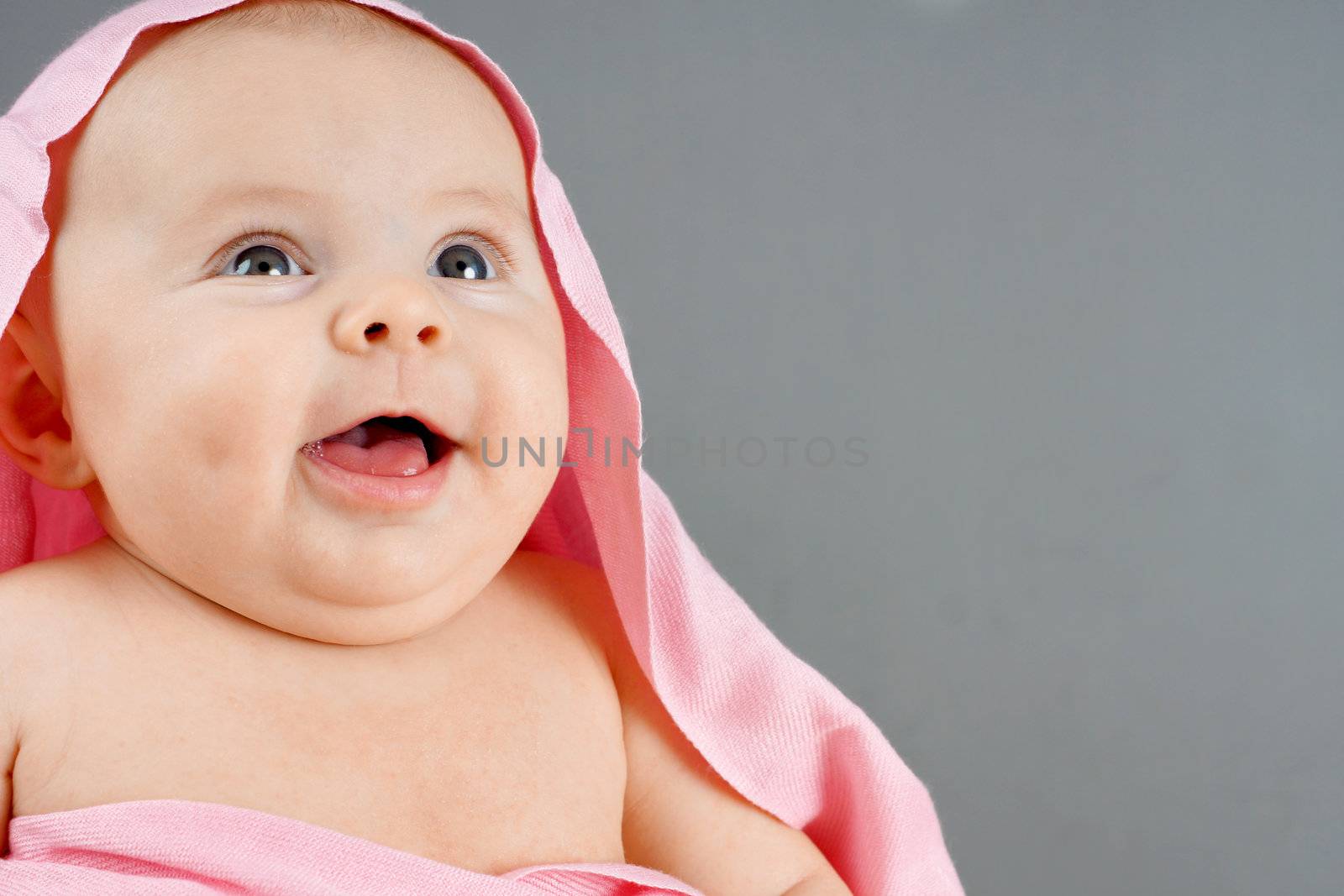 Laughing baby girl with pink blanket