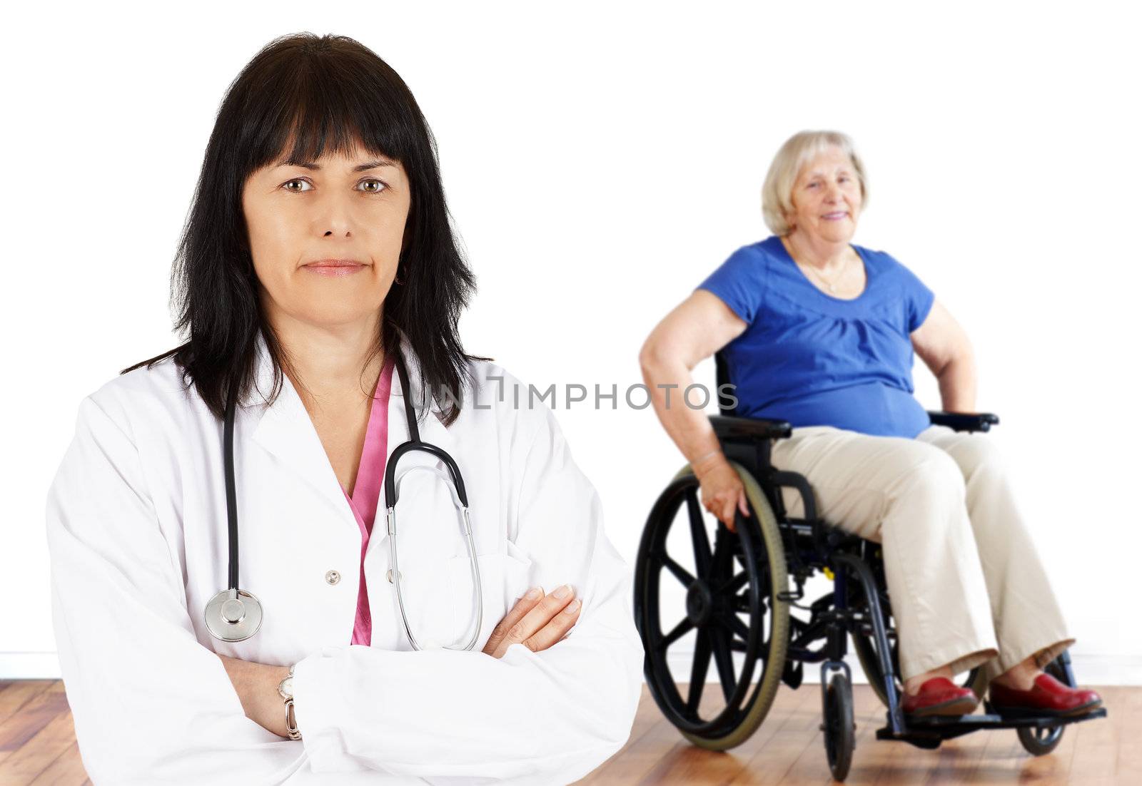 Friendly woman doctor looking at camera with handicap senior in wheelchair in the back