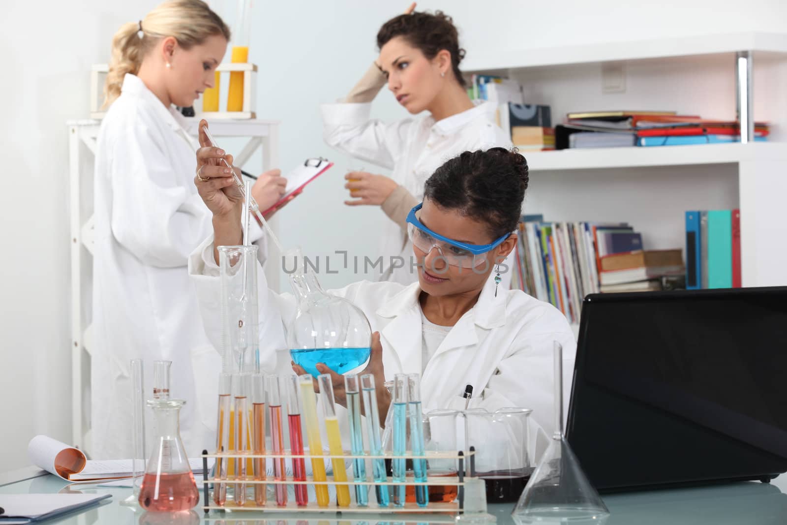 Three women in science laboratory by phovoir