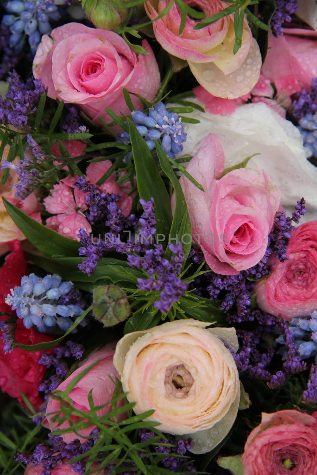 pink roses and ranonkels, blue common hyacints in a spring flower wedding centerpiece