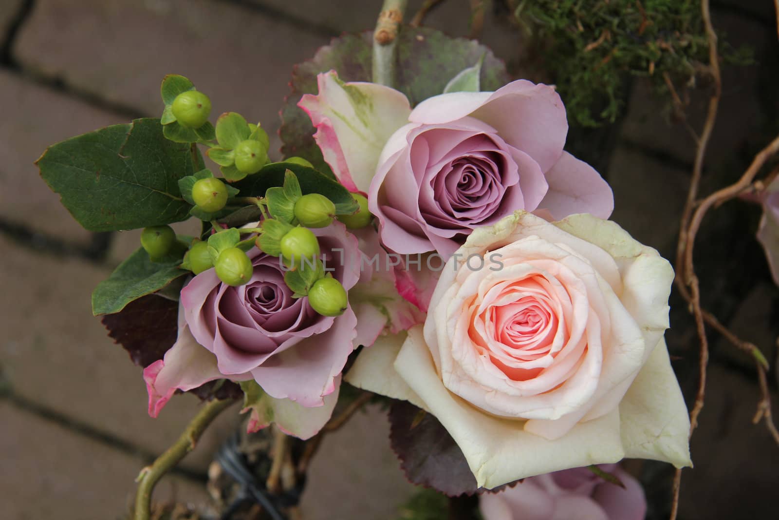 Big pink and purple roses in a wedding centerpiece