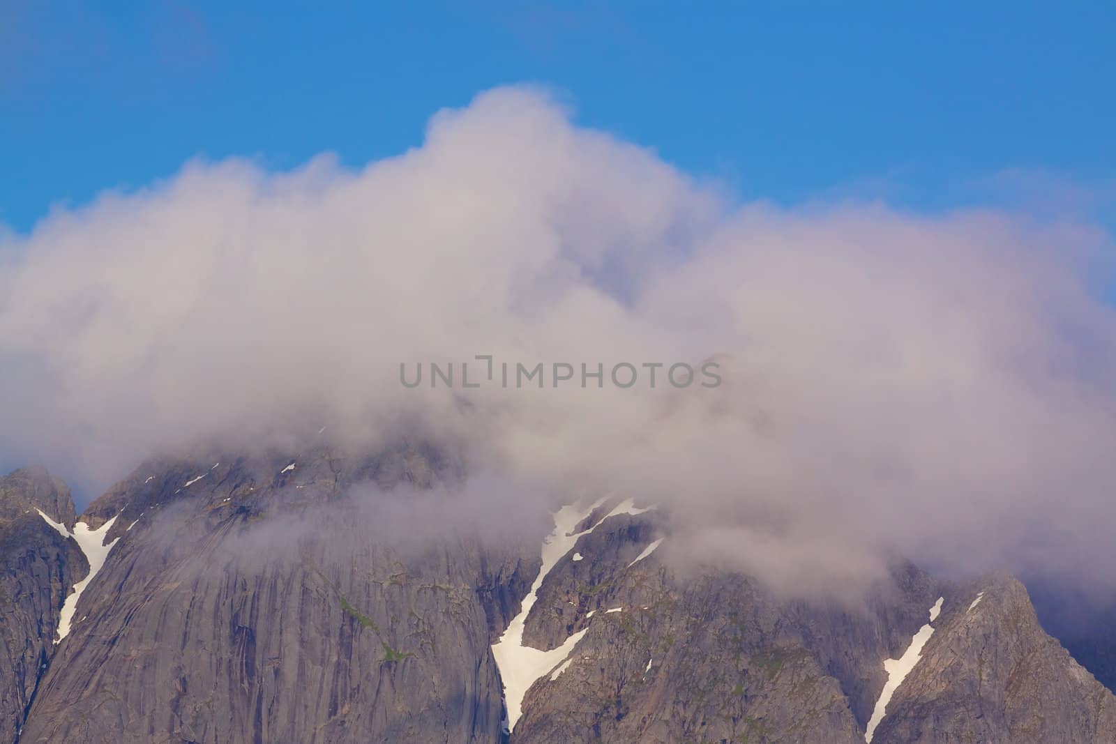 Scenic mountain peaks covered by clouds on Lofoten islands in Norway
