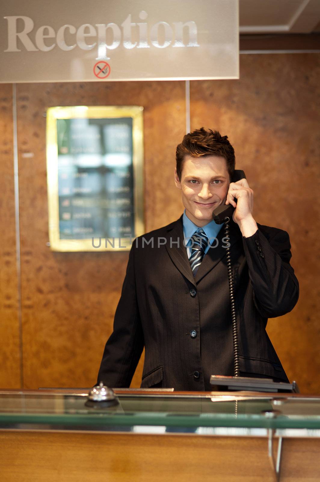 Profile shot of a handsome receptionist on the phone posing in front of camera