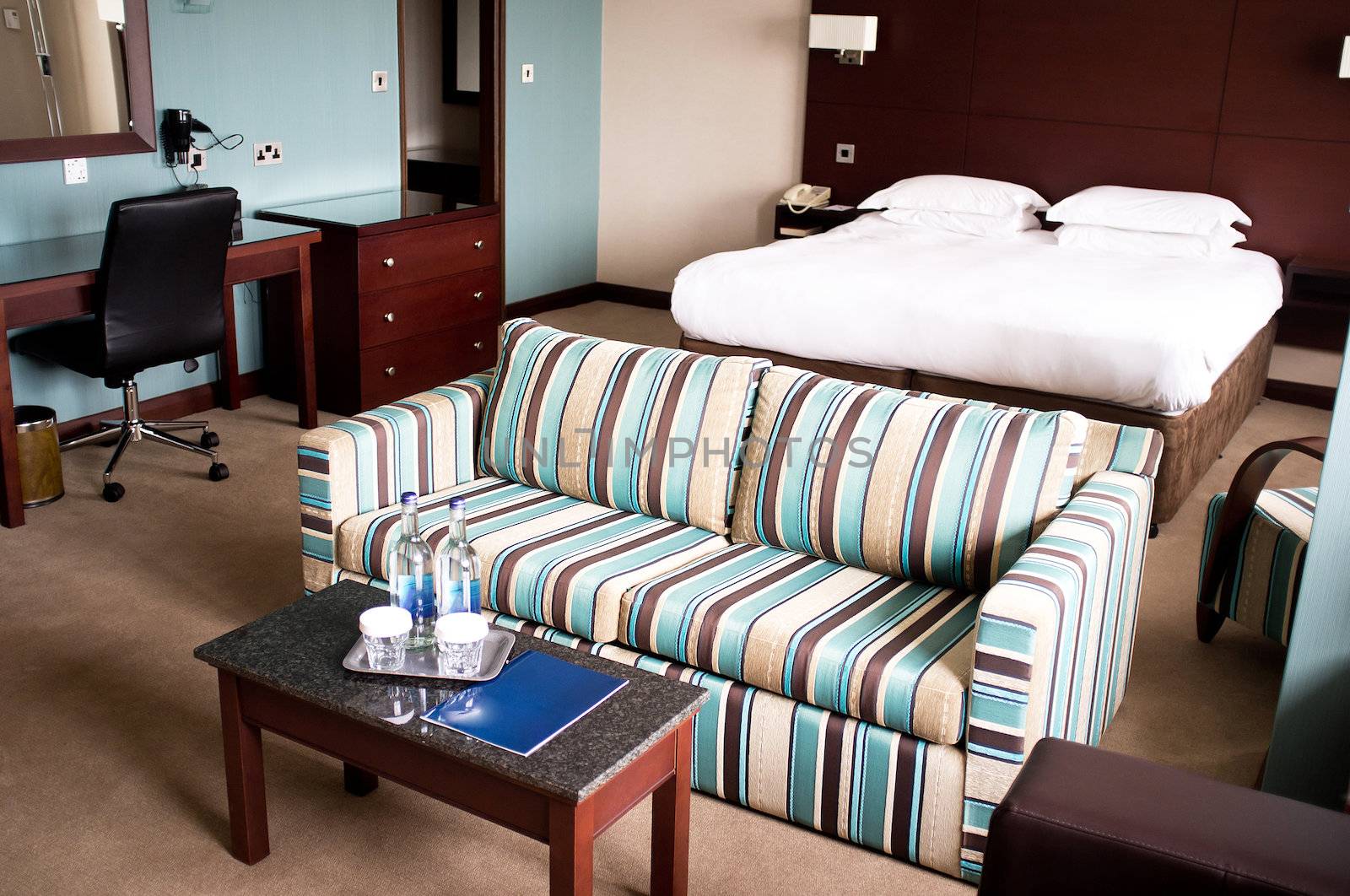 Suite room of a hotel with a sofa neatly placed in the middle and mini table placed