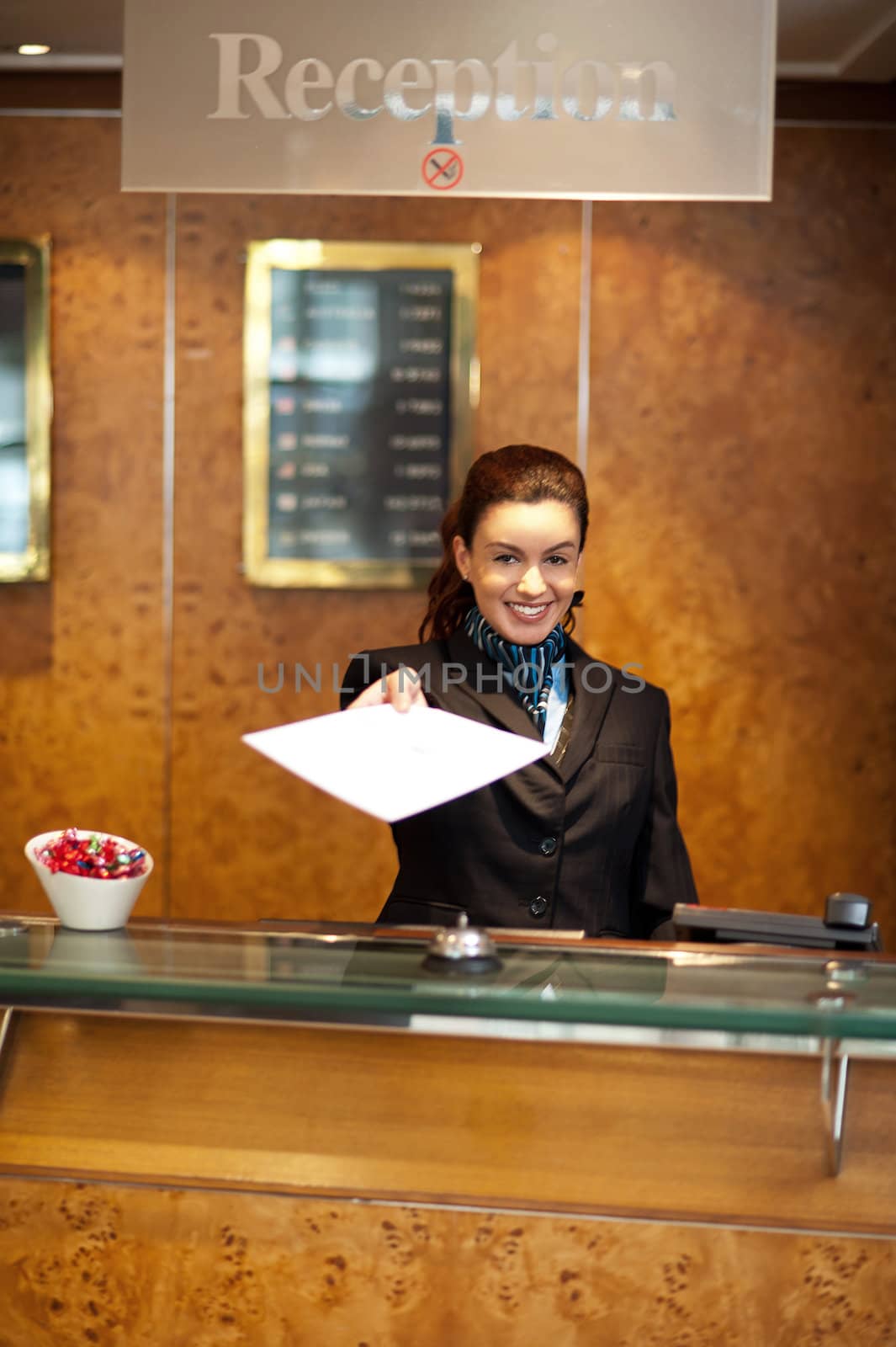 Female receptionist handing over check-out papers along with bill to the customer