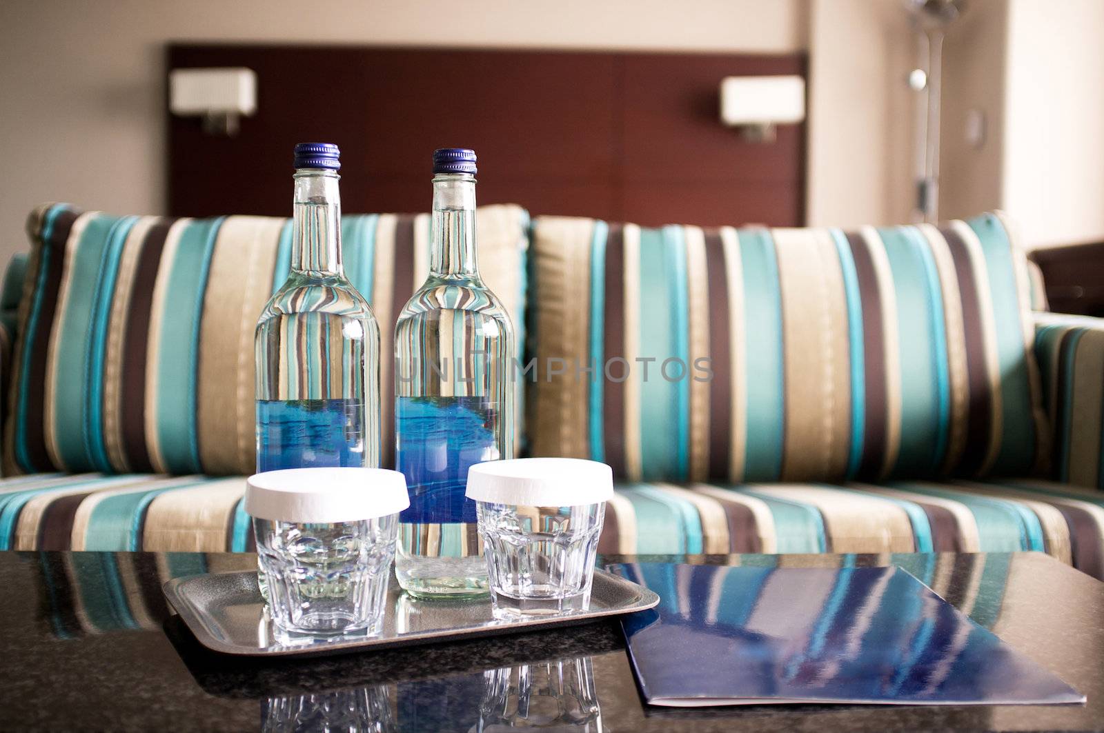 Hotel room shot. Beverage bottles in focus with couch in the background