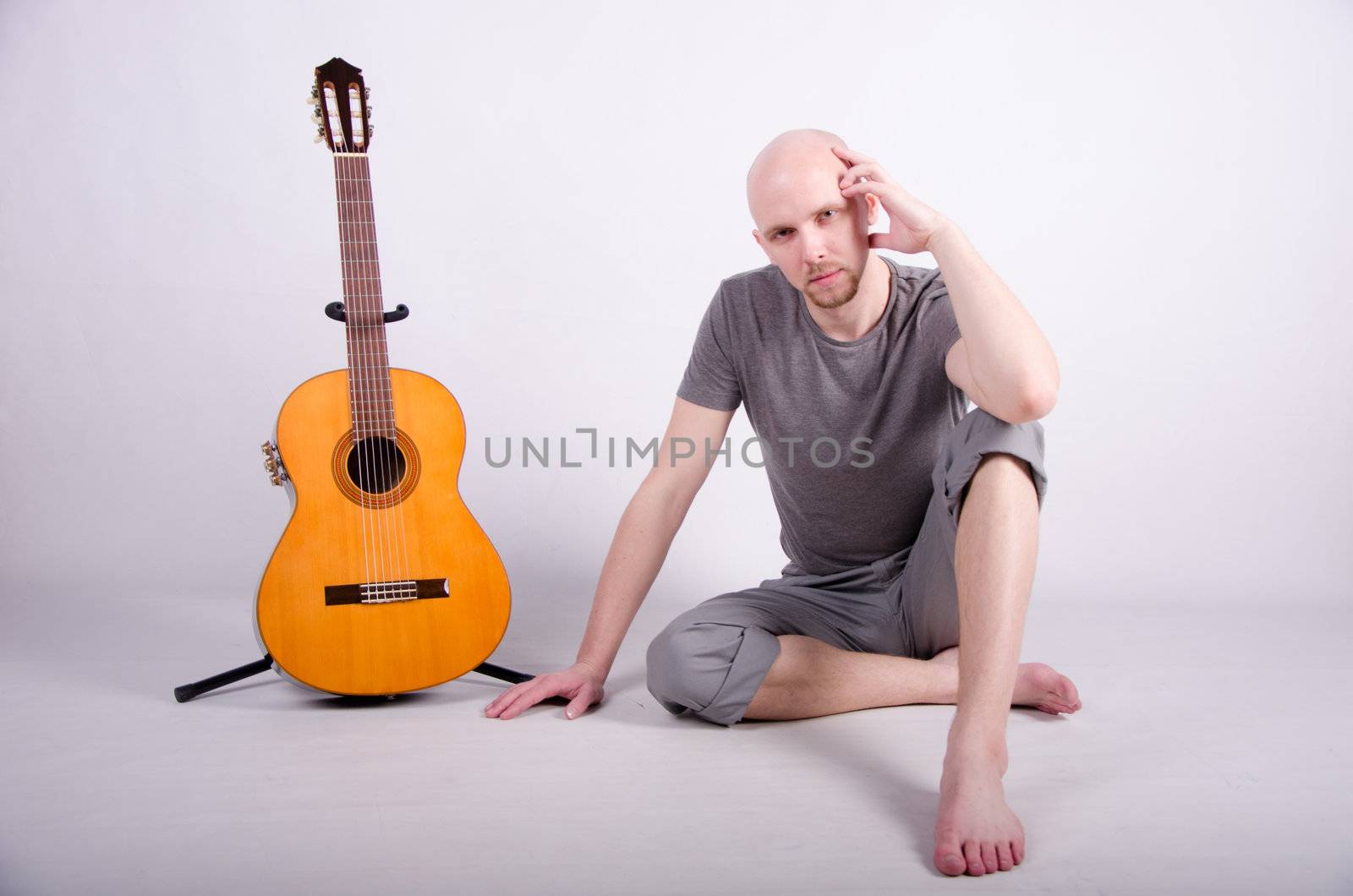 Nice bald guy with a guitar in the studio