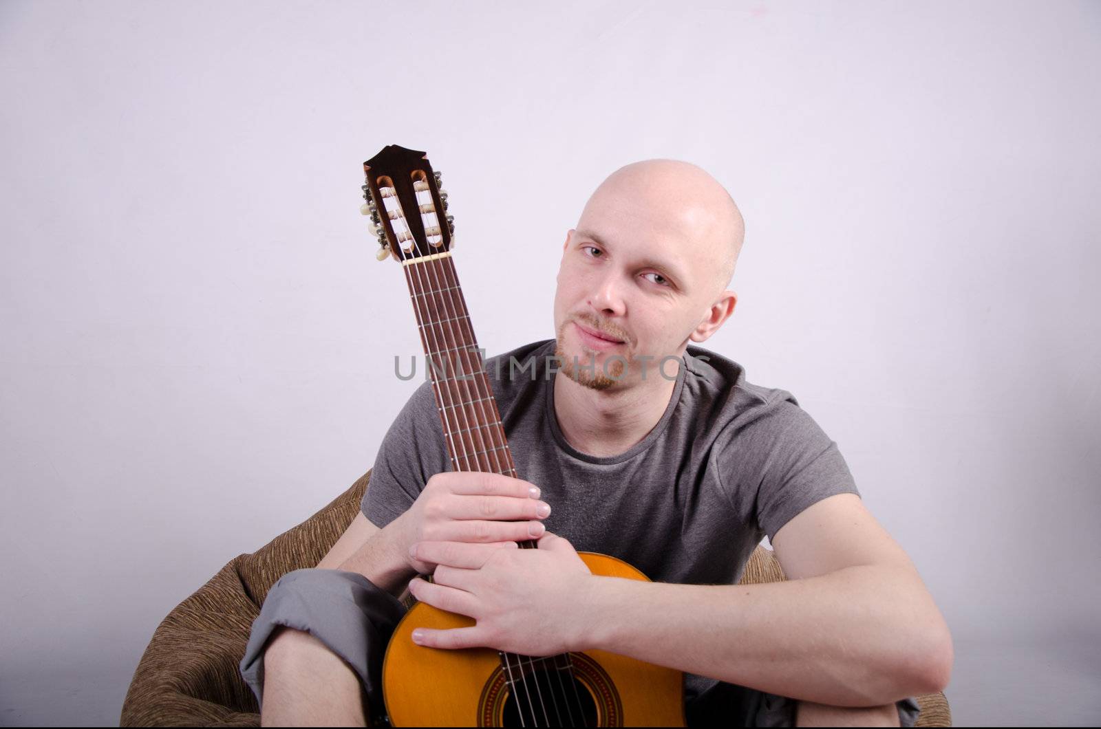 Nice bald guy with a guitar in the studio