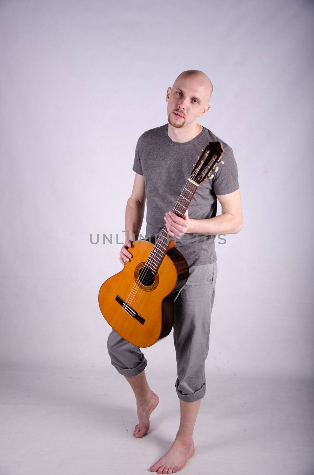 Nice bald guy with a guitar in the studio