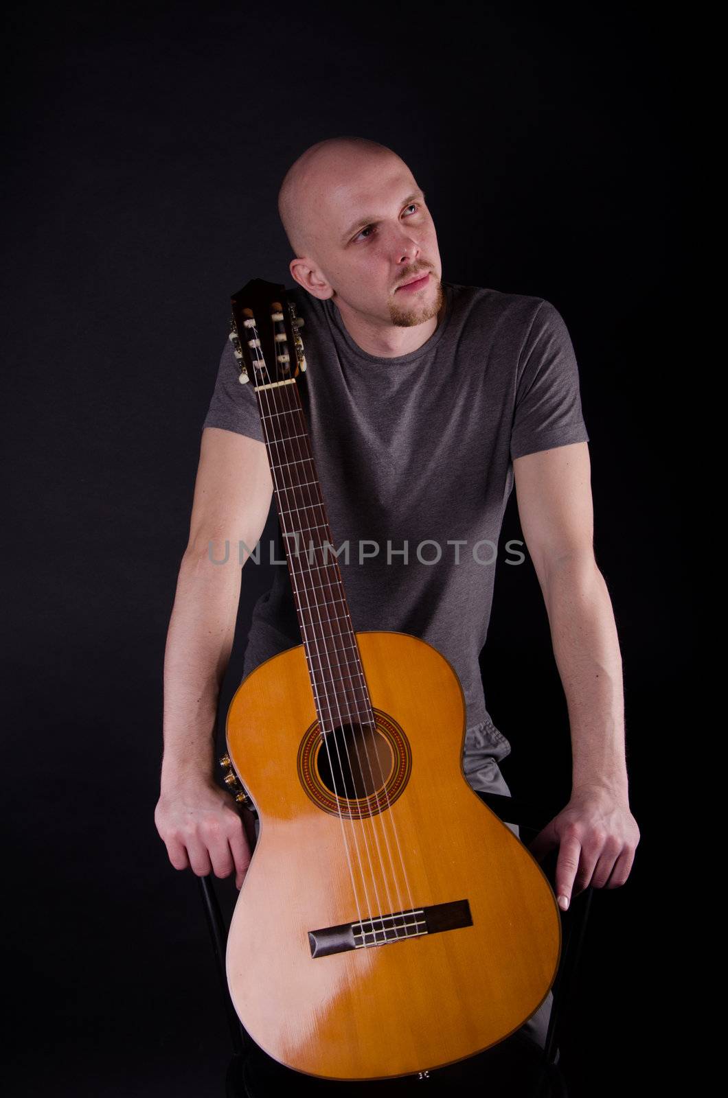 Nice bald guy with a guitar in the studio