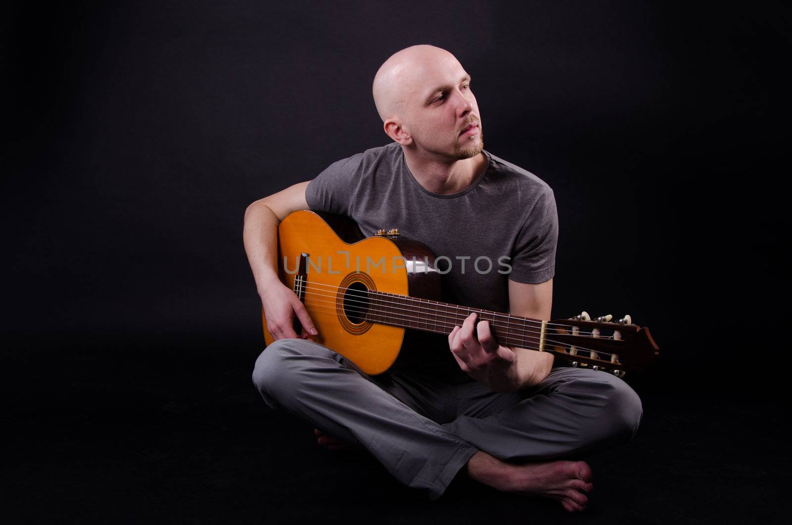 Nice bald guy with a guitar in the studio