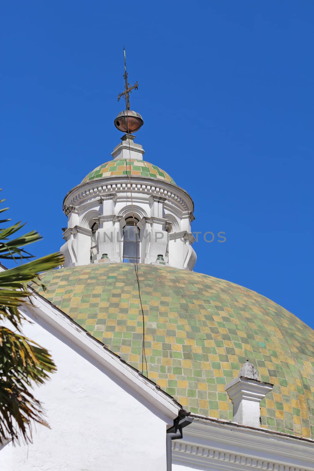 Close-up of a dome with a cross from the courtyard of the church and monastery of San Francisco in Quito, Ecuador