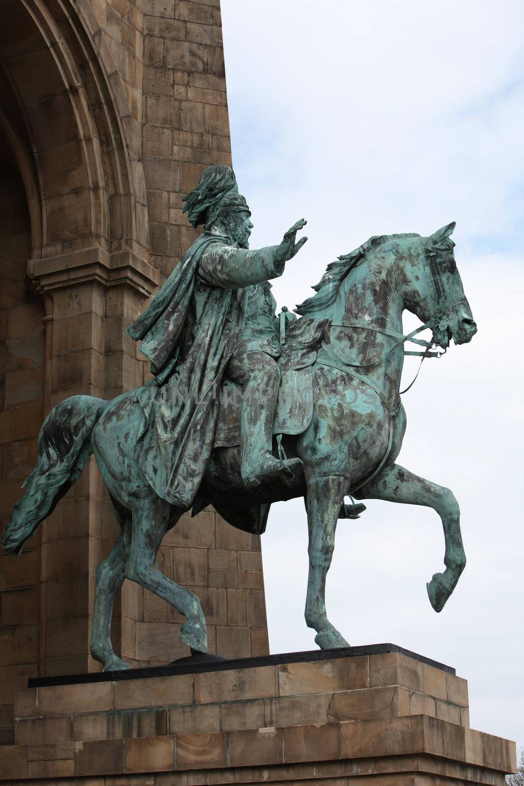 Low angle view of a bronze statue of Kaiser Wilhelm mounted on horseback with his hand raised in greeting
