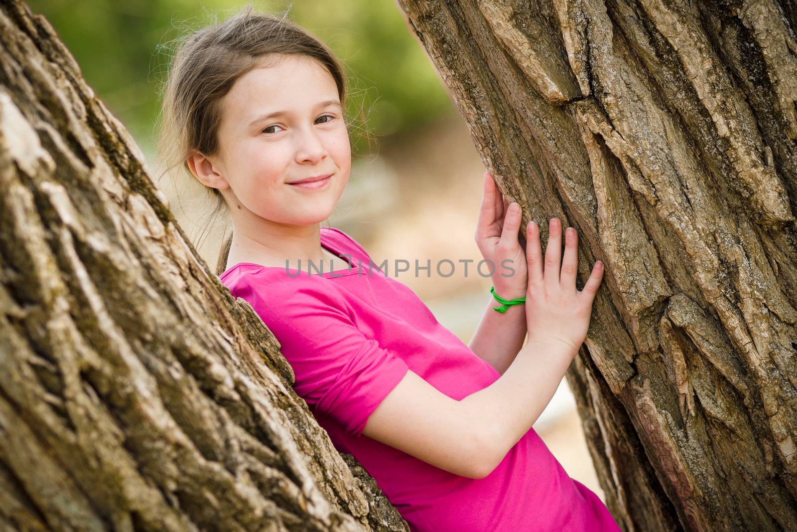 Young girl standing between two trees