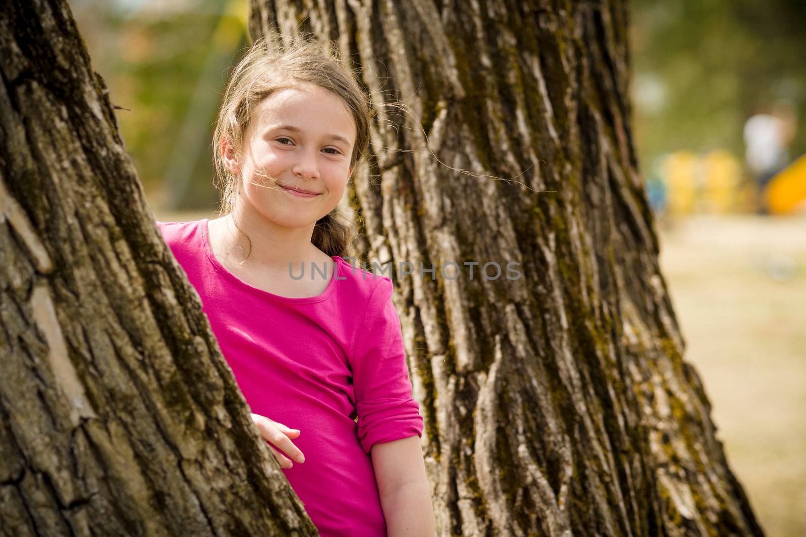 Young girl standing between two trees