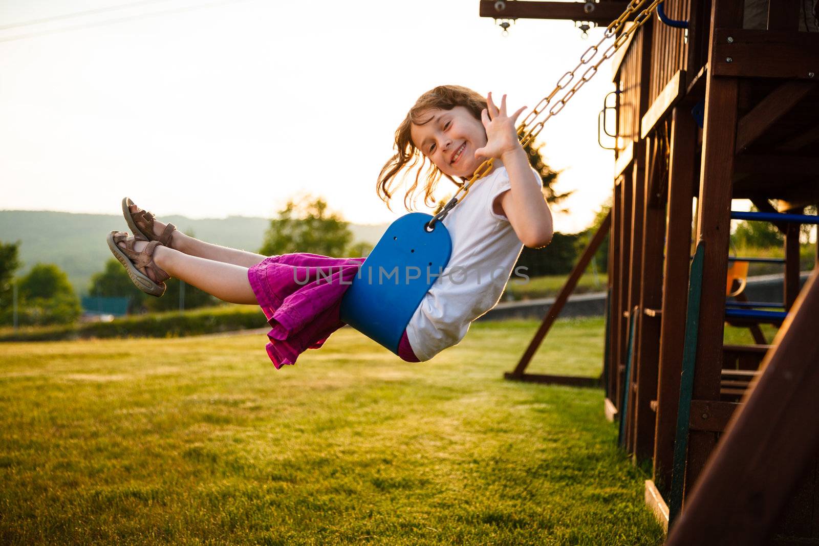 Little girl on a swing in a playground