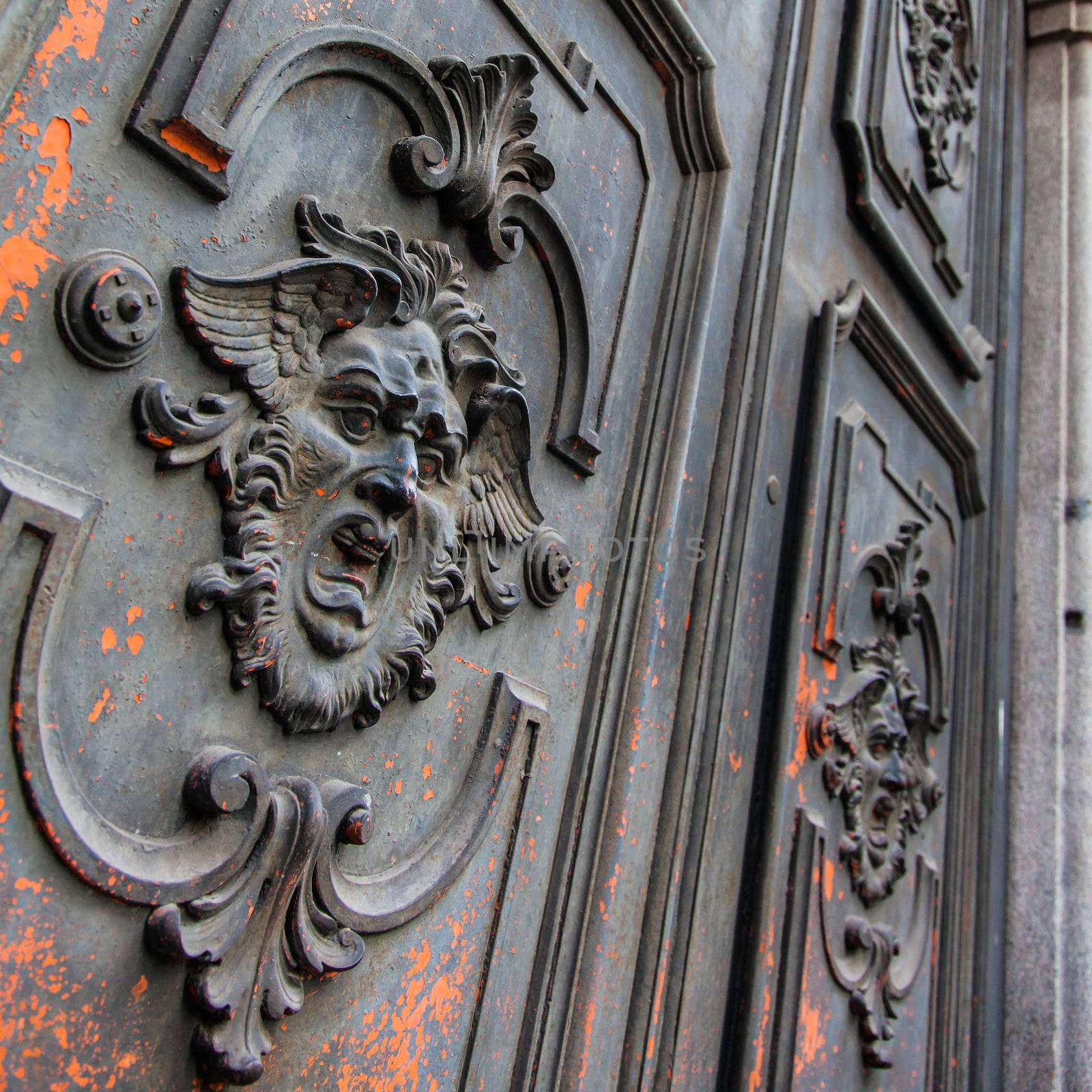 Gothic mask on an old wodden door in Milan - Italy