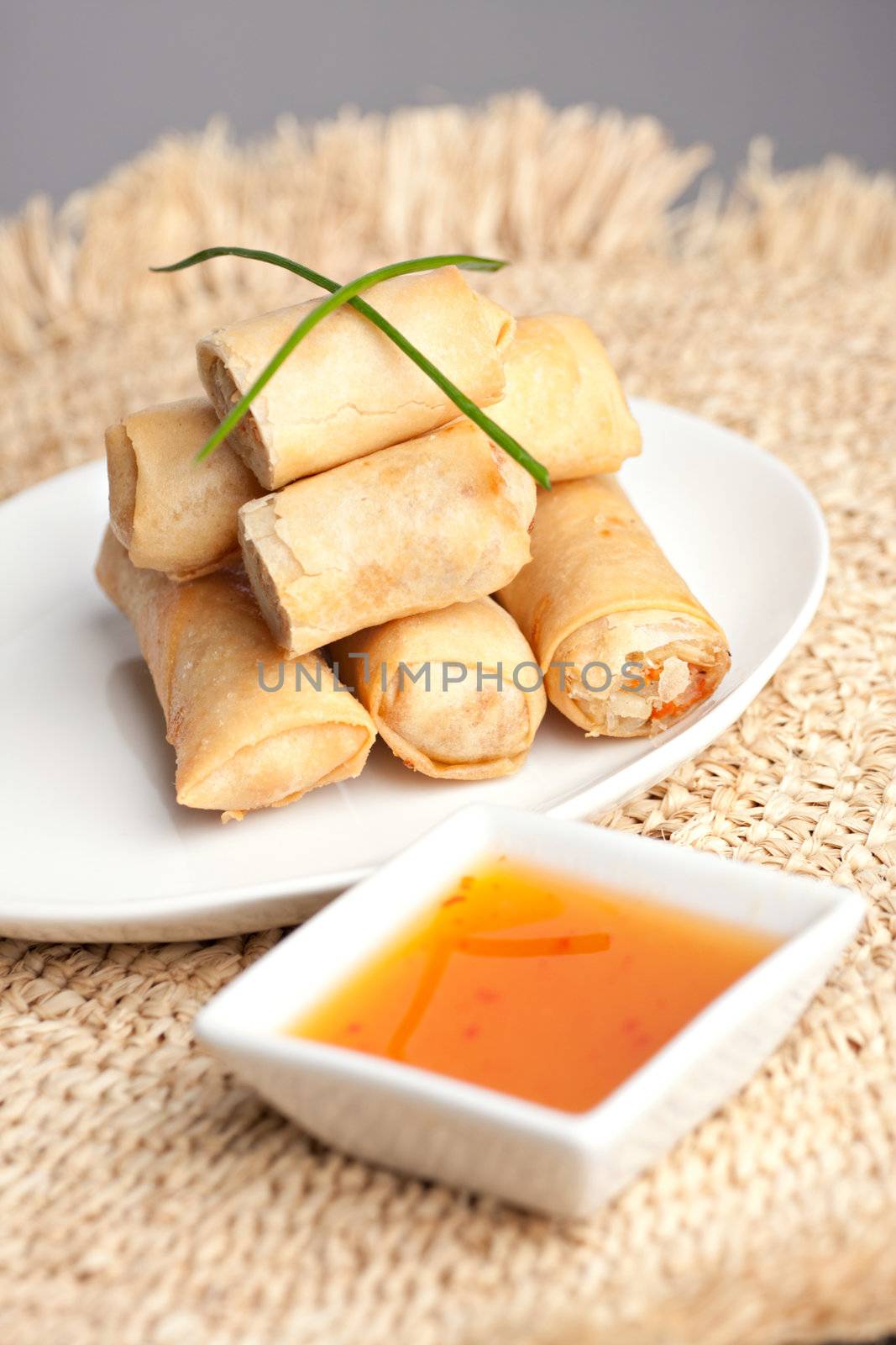 Plate of Thai spring rolls appetizer with garnish. 