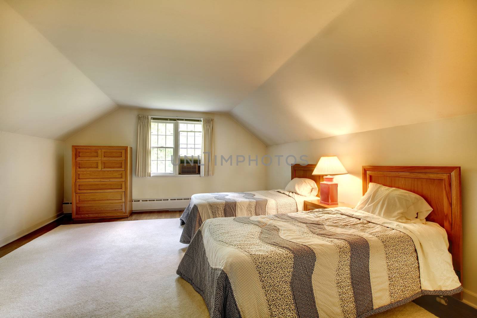 Attic bedroom with simple furniture and vaulted ceiling.