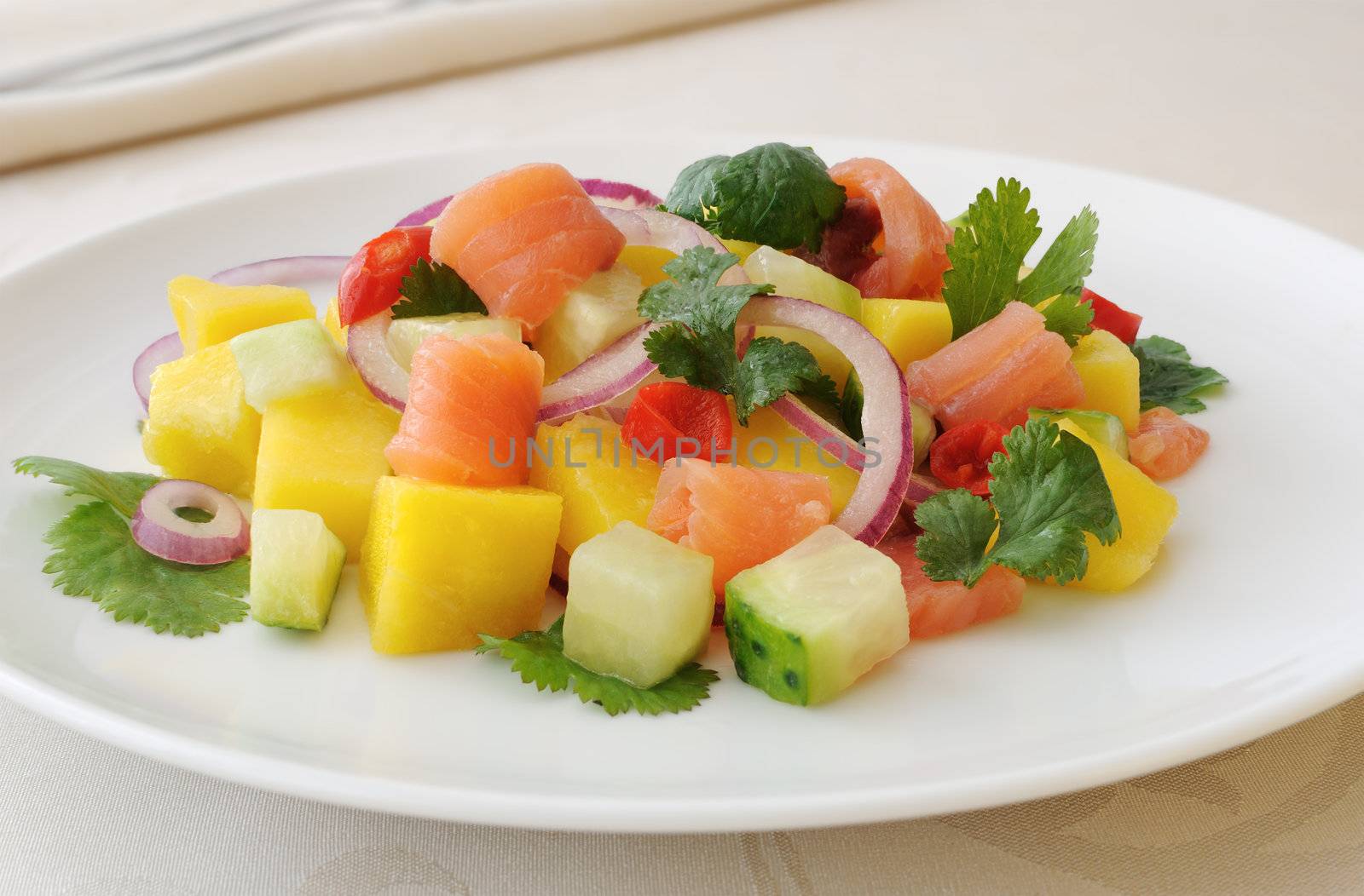 dish of crème Norwegian salmon marinated in lemon juice and coriander, mango, cucumber and red pepper, chili.
