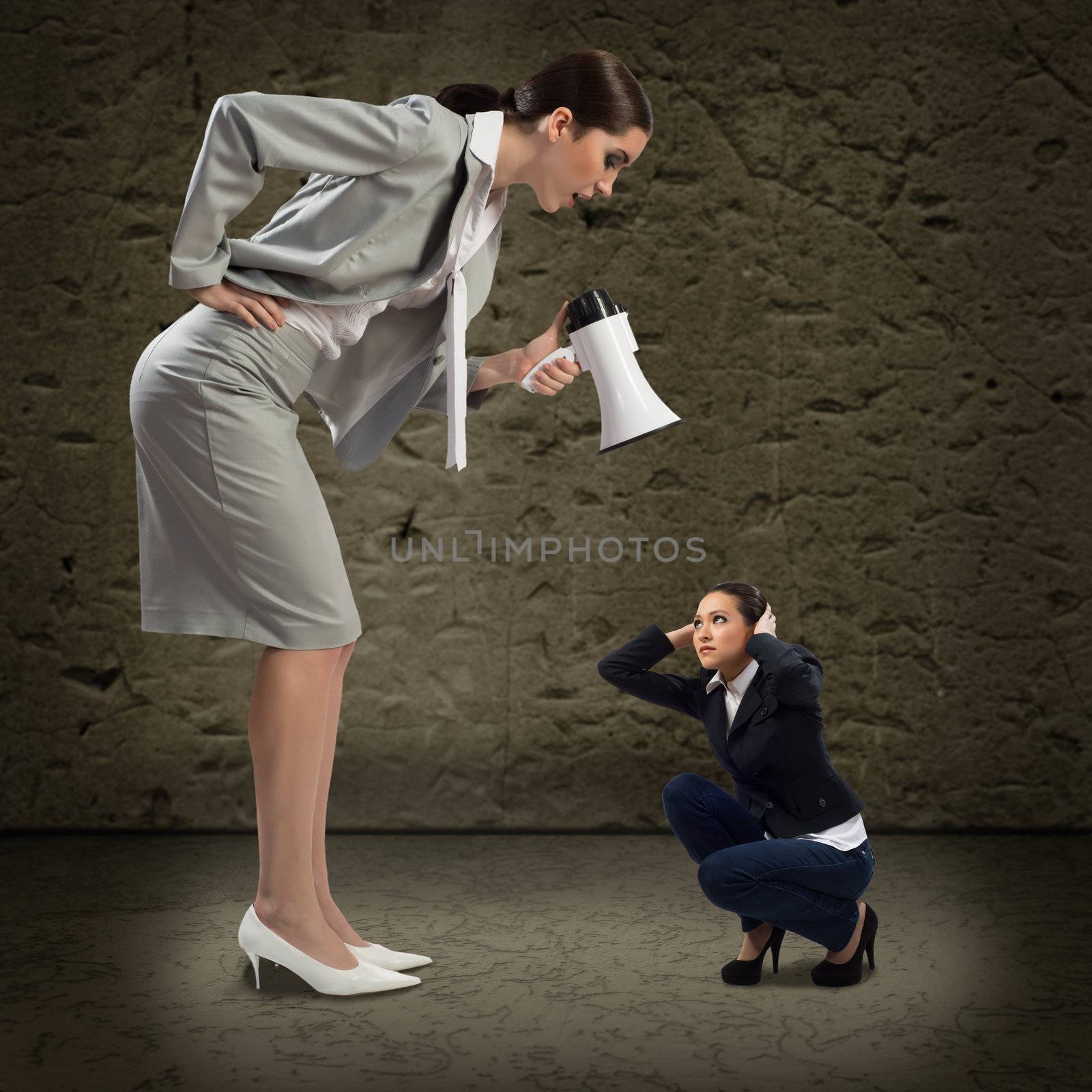 Business woman yelling at a small woman sitting on the ground, the concept of aggression