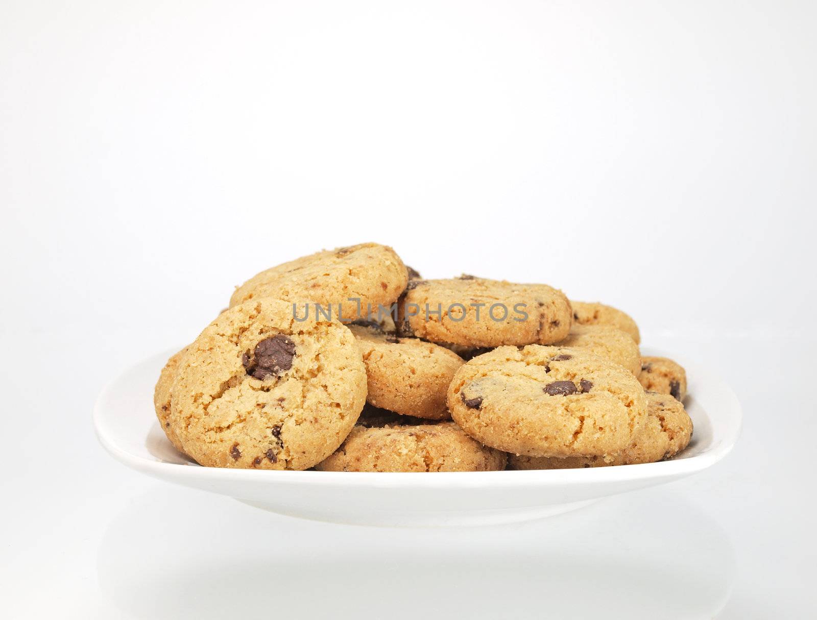 bowl of chocolate chip cookies on white background