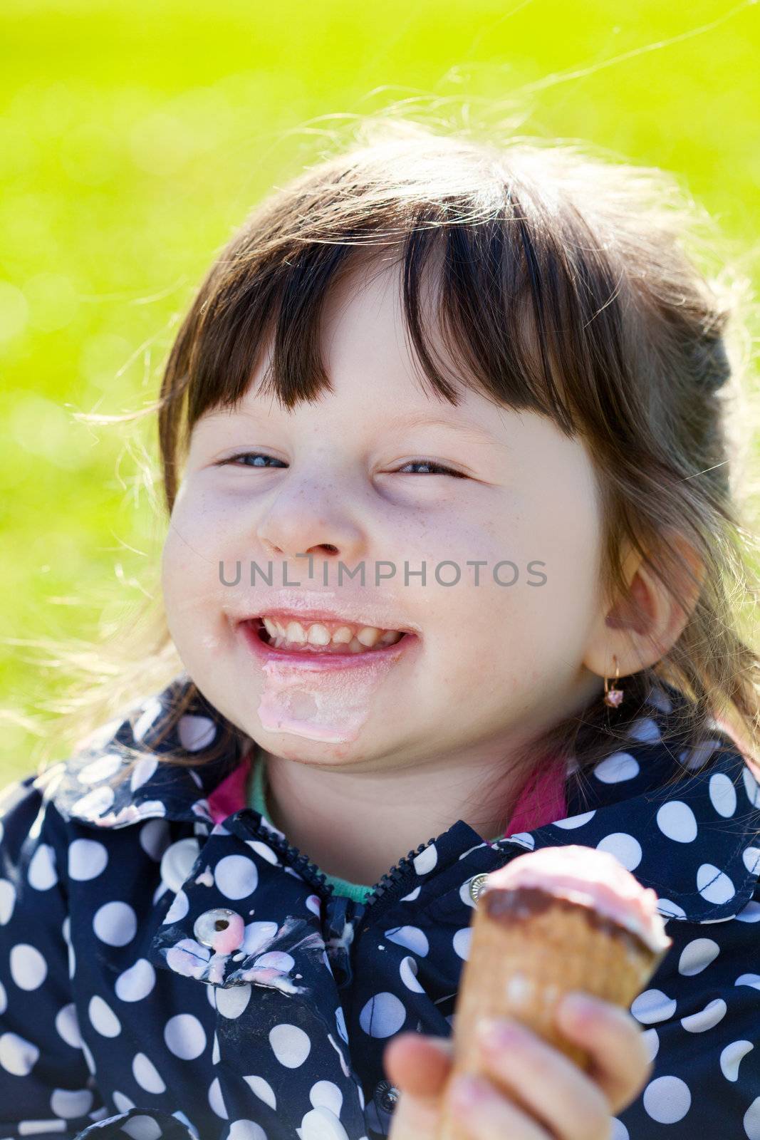 joyful little girl with ice cream on the street