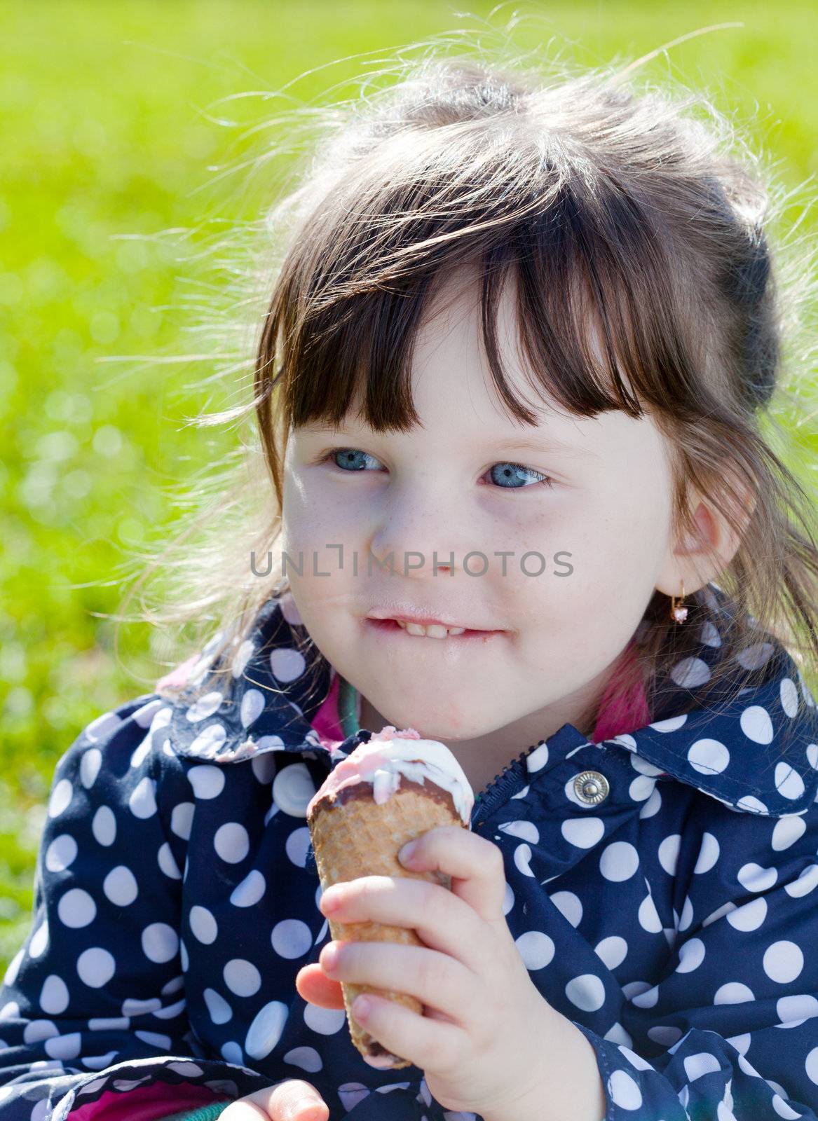  happy girl eats ice cream on the street in spring day