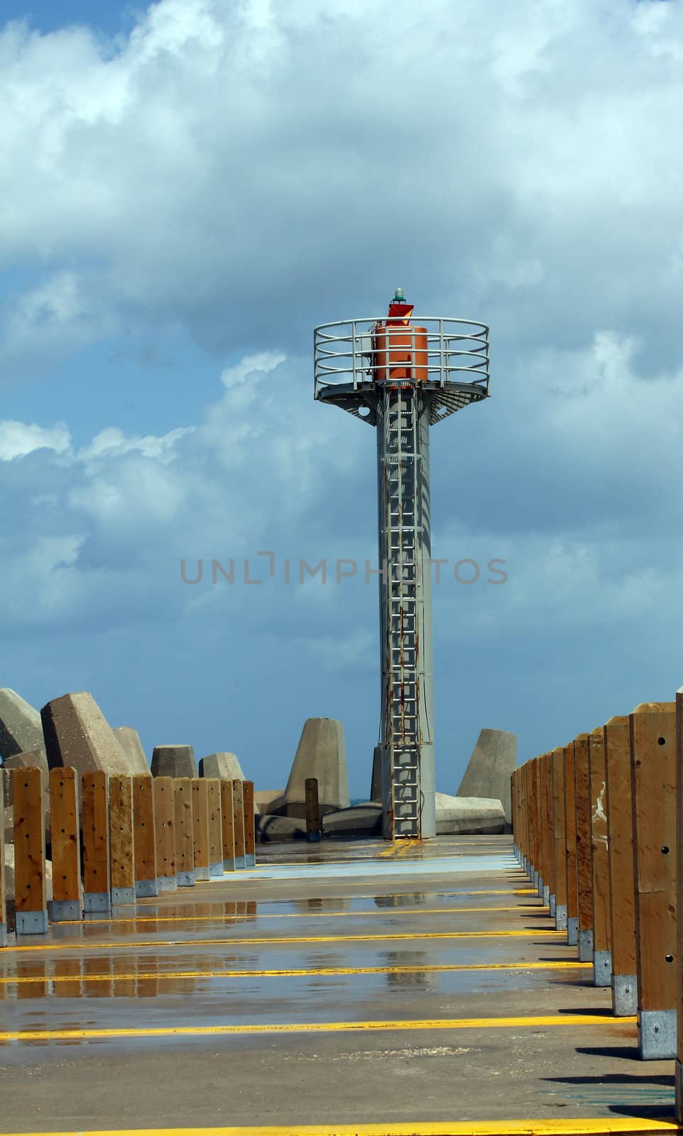 Lighthouse on the walking walls off the marina from the sea