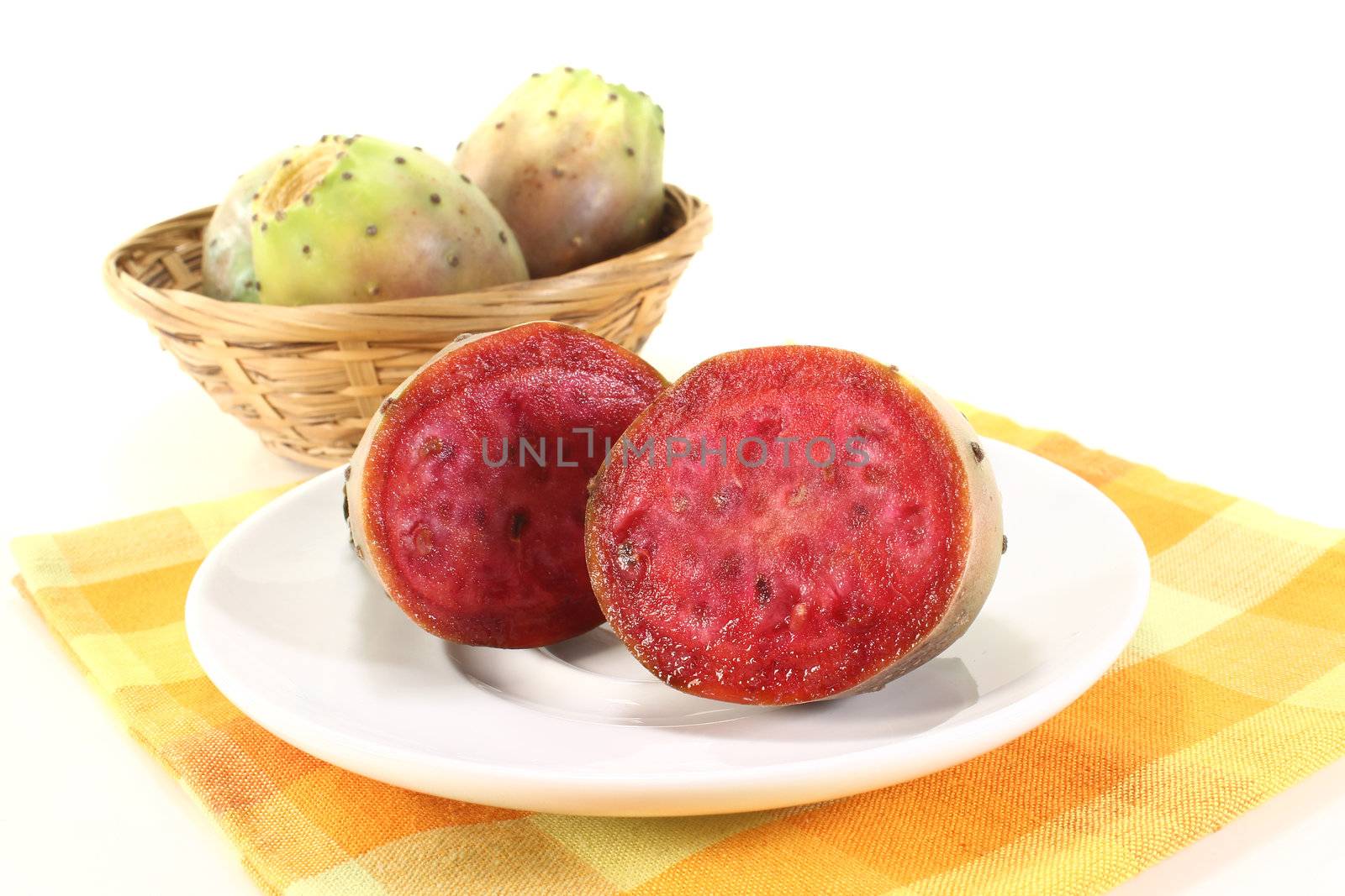 red succulent cactus figs on a plate in front of light background