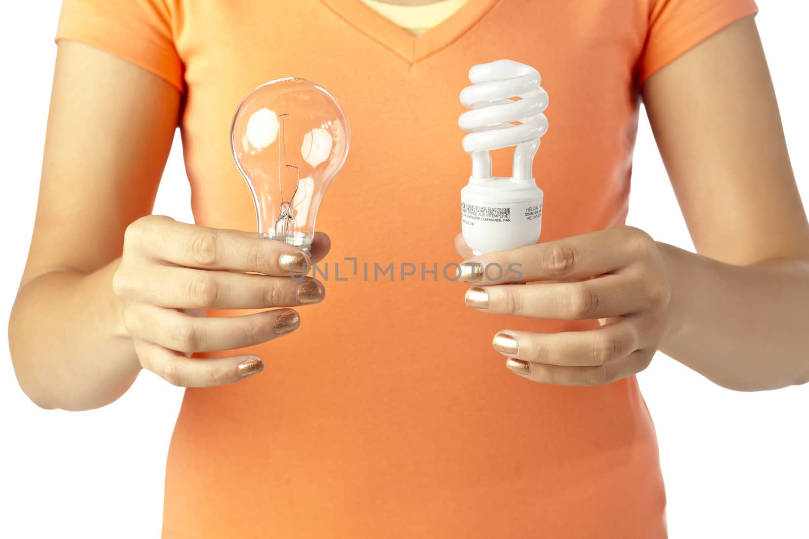 Close up image of human hand holding two different kinds of light bulbs against white background