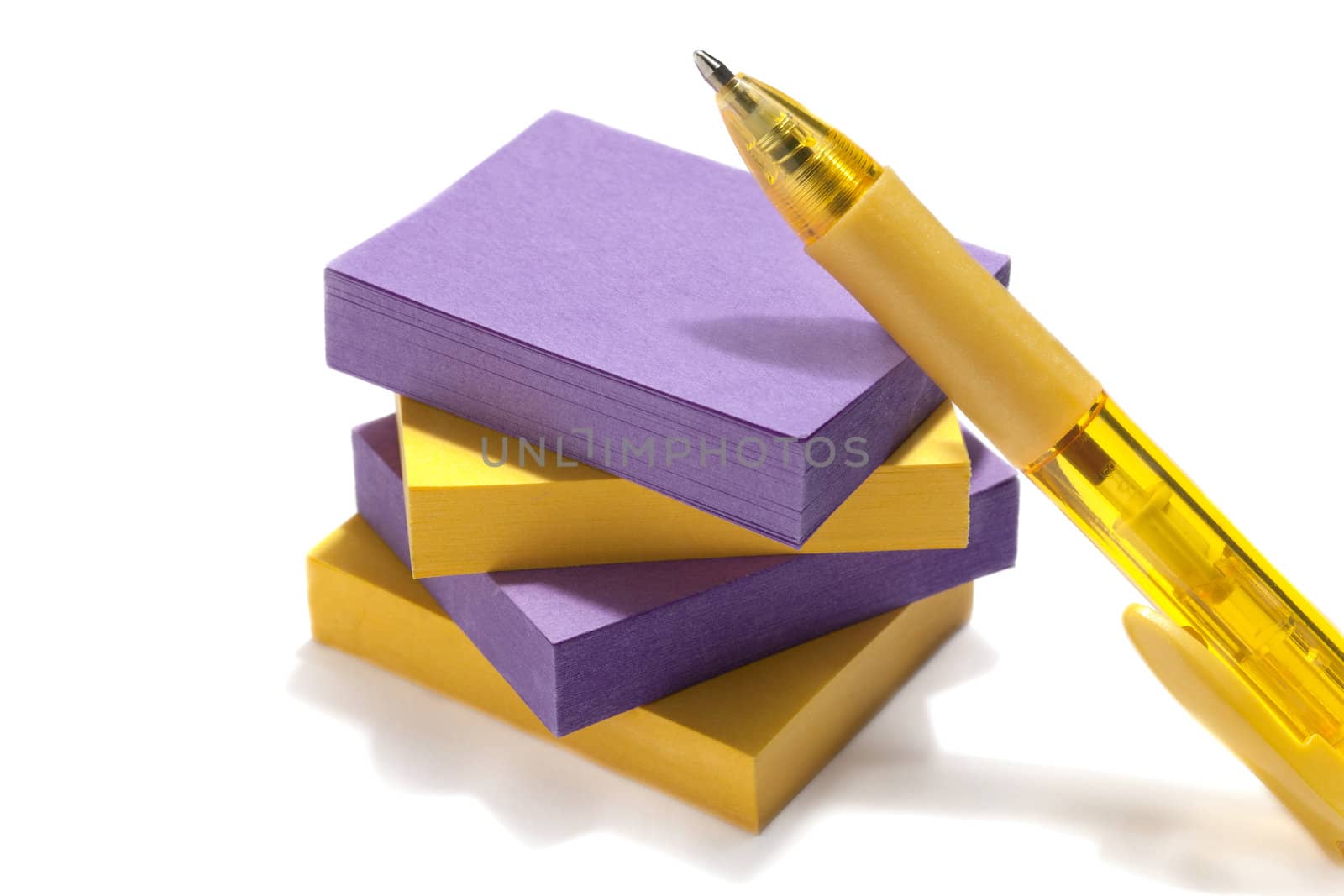 Stack of colorful post-it notes with yellow pen on a white background
